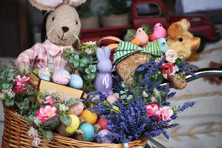 Festive Easter basket filled with decorated eggs, flowers, and plush animals, creating a vibrant holiday display.