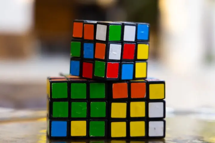Close-up of two stacked Rubik's Cubes showcasing multi-colored squares for puzzle enthusiasts.