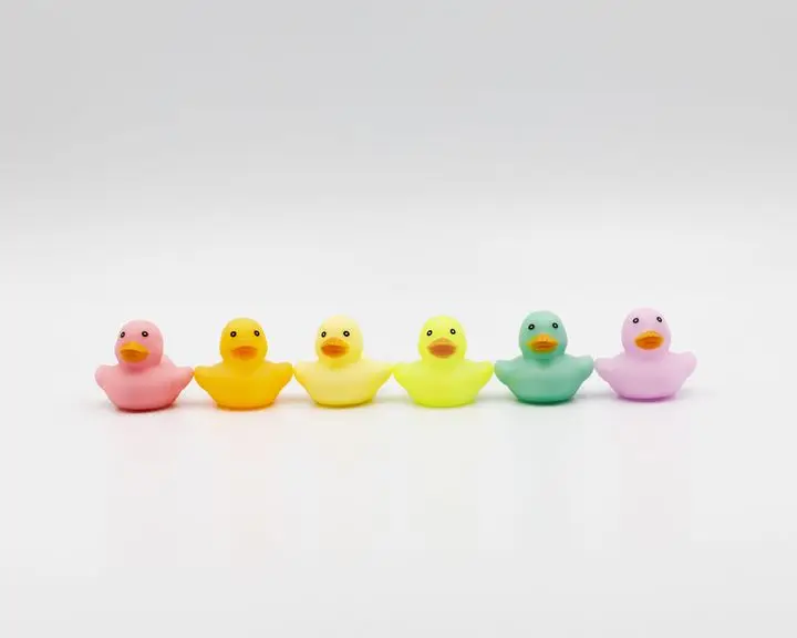 Vibrant multicolored rubber ducks in a row on a clean white background.