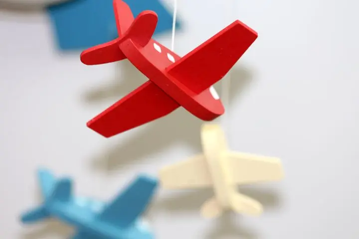 A close-up of colorful wooden airplane toys in a mobile, perfect for nursery décor.