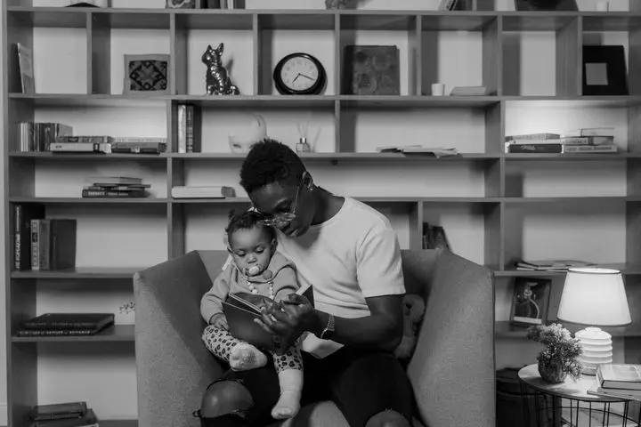 A father and child reading together in a cozy, book-filled room showcasing bonding and family time.