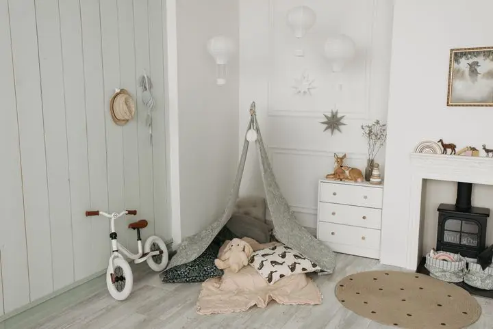 Charming children's room featuring a play tent, balance bike, and cozy interior design.