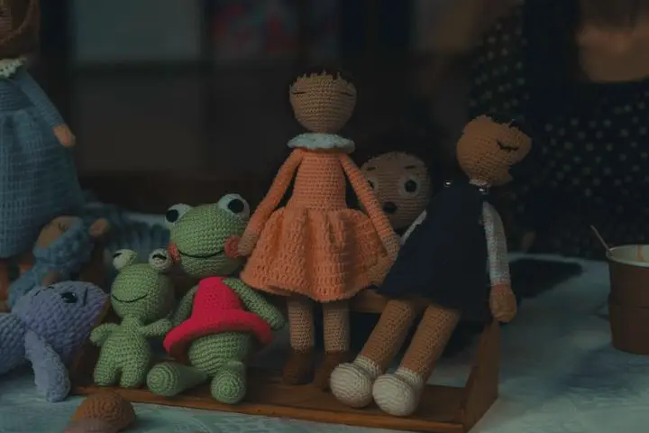 A delightful set of handmade knitted dolls and stuffed animals on display, showcasing intricate craftsmanship.