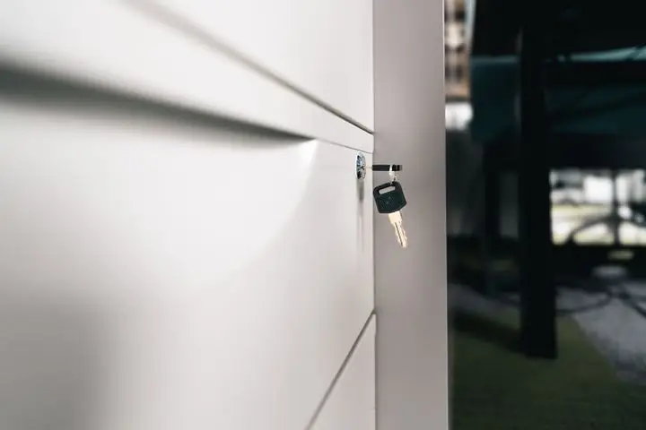 Close-up of a key in a locked office drawer for secure storage and privacy.