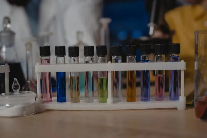 Close-up of test tubes with colored liquids in a laboratory setting.