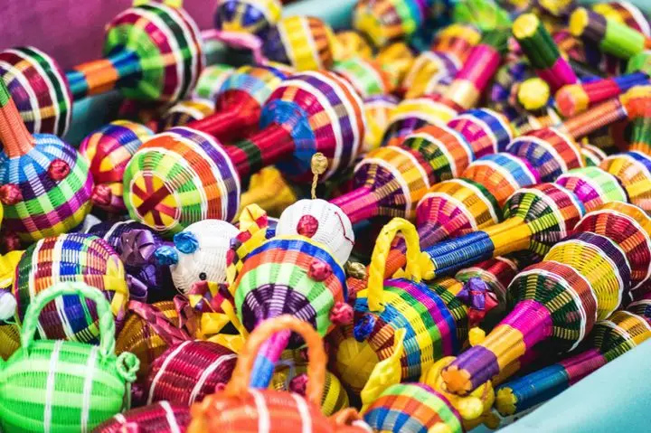 Colorful handmade Mexican rattles woven with vibrant patterns, showcasing traditional craftsmanship.